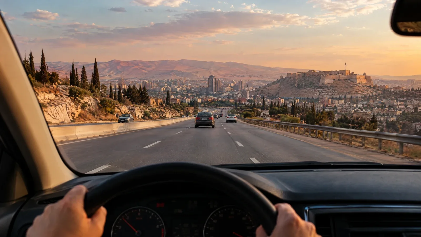 The view from a car traveling along a Syrian road toward a city.